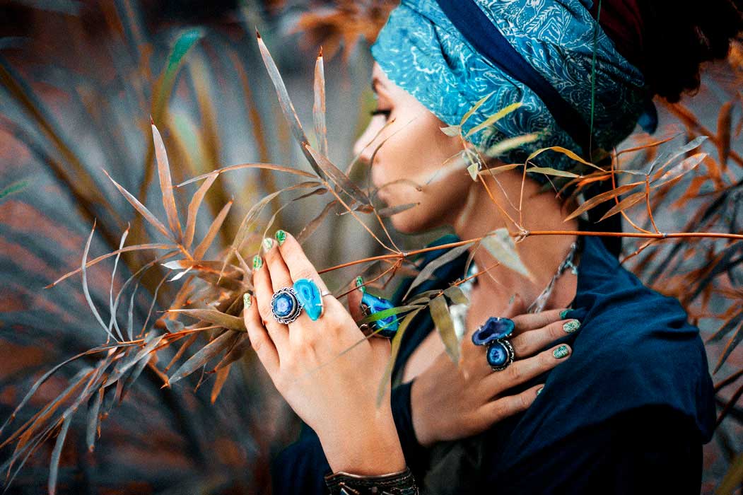 fille portant des bagues avec pierres naturelles bleues, dans un champ